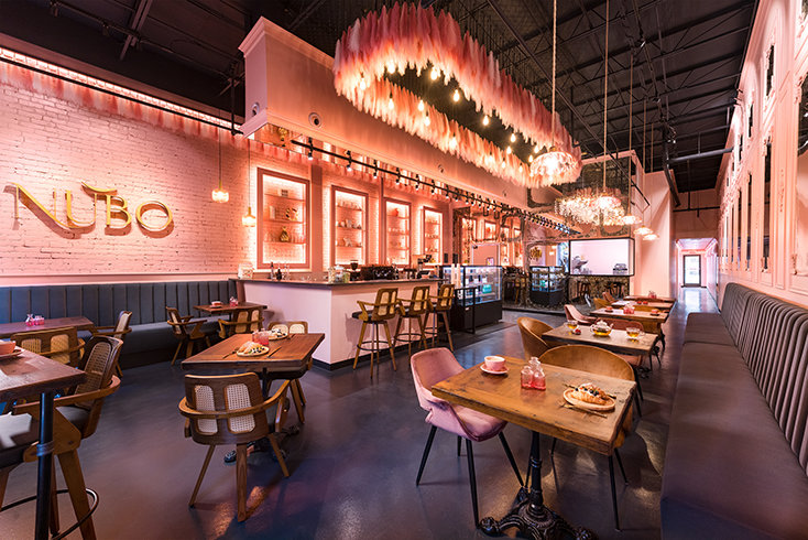 Nubo’s renovated interior combines warm lighting, pink-and-gold finishes, café seating and bakery displays to create a memorable new gathering place on Cleveland Street.