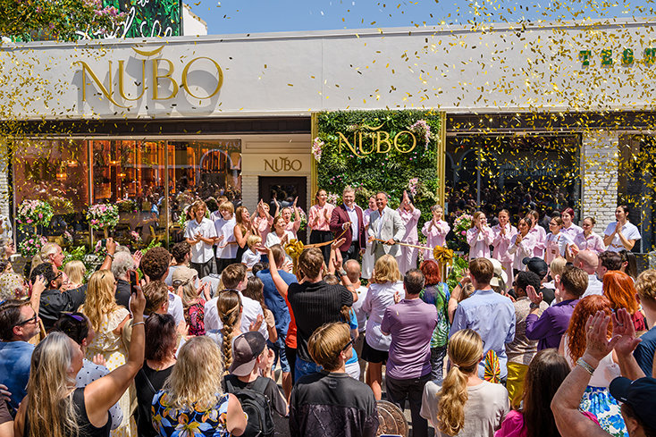 Confetti fills the air as Nubo owner Oleksandr Kozlenko and the Nubo team cut the ribbon together, opening the Ukrainian café and bakery at 420 Cleveland Street.