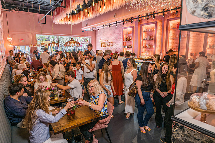 Inside Nubo Café & Bakery, guests fill the pink-and-gold dining area as the new restaurant begins welcoming residents, workers and visitors to the 400 block.