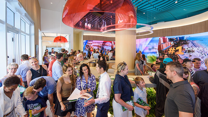 Visitors circulate through the showroom’s central space, engaging with large-scale media presenting the evolution of the Cleveland Street corridor.